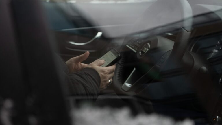 A driver uses their smartphone while stopped at a traffic light in Halifax, Wednesday, Jan. 10, 2024. (THE CANADIAN PRESS/Darren Calabrese)