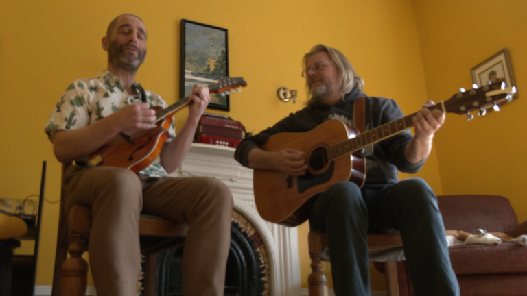 Dave Penny, left, and Daunt Lee, right, practice a song in a downtown St. John's house before a concert on Nov. 7, 2024. (Garrett Barry, CTV National News)
