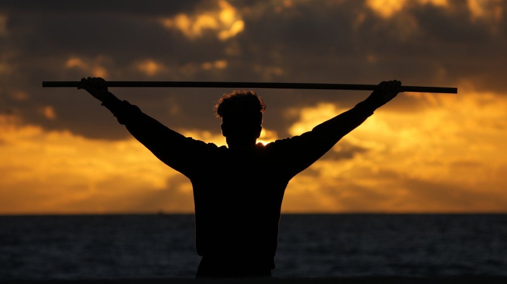 A beach goer exercises as the sun rises above the Atlantic Ocean, Feb. 1, 2023, in Surfside, Fla. (AP Photo/Wilfredo Lee, File)