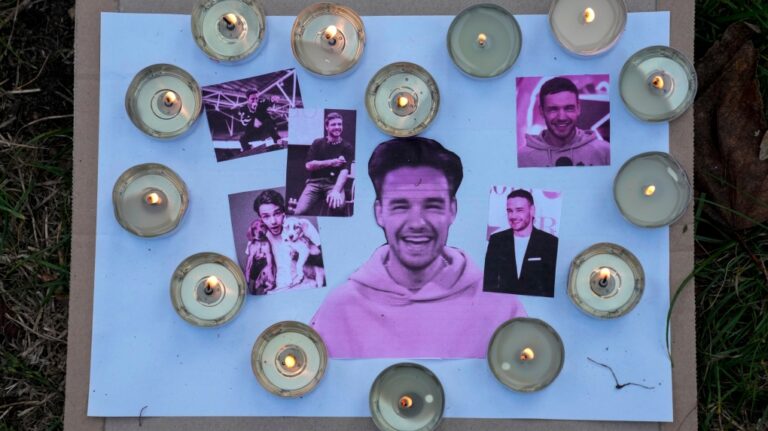 Pictures and candles are placed as fans gather to pay tribute to late British singer Liam Payne, former member of the British pop band One Direction, in Treptower Park in Berlin, Germany, Sunday, Oct. 20, 2024. (AP Photo/Ebrahim Noroozi)