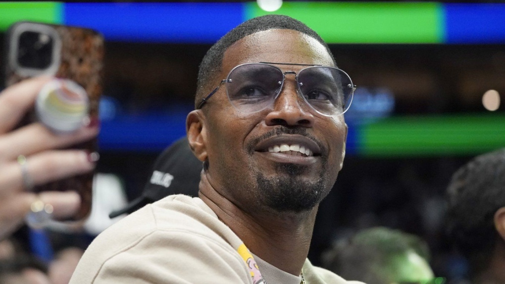 Jamie Foxx smiles during an NBA basketball game between the Washington Wizards and Dallas Mavericks in Dallas, Saturday, Nov. 27, 2021. (AP Photo/LM Otero, File)