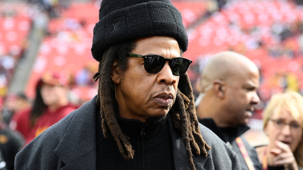 Musician Jay-Z stands on the field before an NFL football game between the Washington Commanders and Dallas Cowboys, Nov. 24, 2024, in Landover, Md. (AP Photo/Nick Wass, File)
