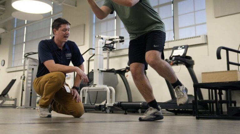 Physical therapist Tyler Detmer, left, works with patient Jacob Bullard at WashU, Monday, Dec. 16, 2024, in St. Louis. (AP Photo/Jeff Roberson)