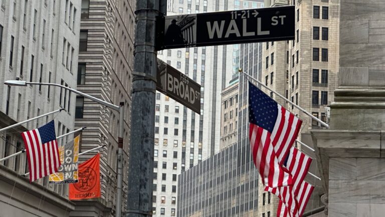 American flags hang from the front the New York Stock Exchange, right, on April 11, 2024 in New York. (Peter Morgan / The Associated Press)