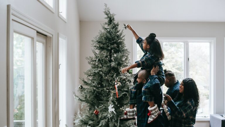 Undated photo of a family decorating a Christmas tree. (Photo by Any Lane from Pexels)