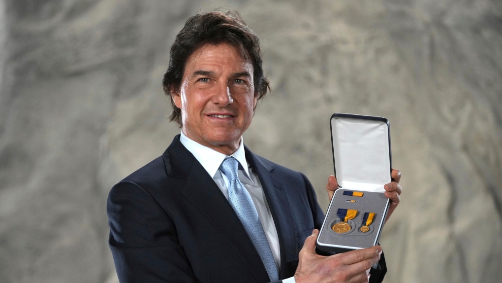 Tom Cruise poses with the Navy Distinguished Public Service Award received from United States Secretary of the Navy Carlos Del Toro, at the Longcross South Studios, in Runnymede, Surrey, England, Dec. 17, 2024. (AP Photo/Kin Cheung)