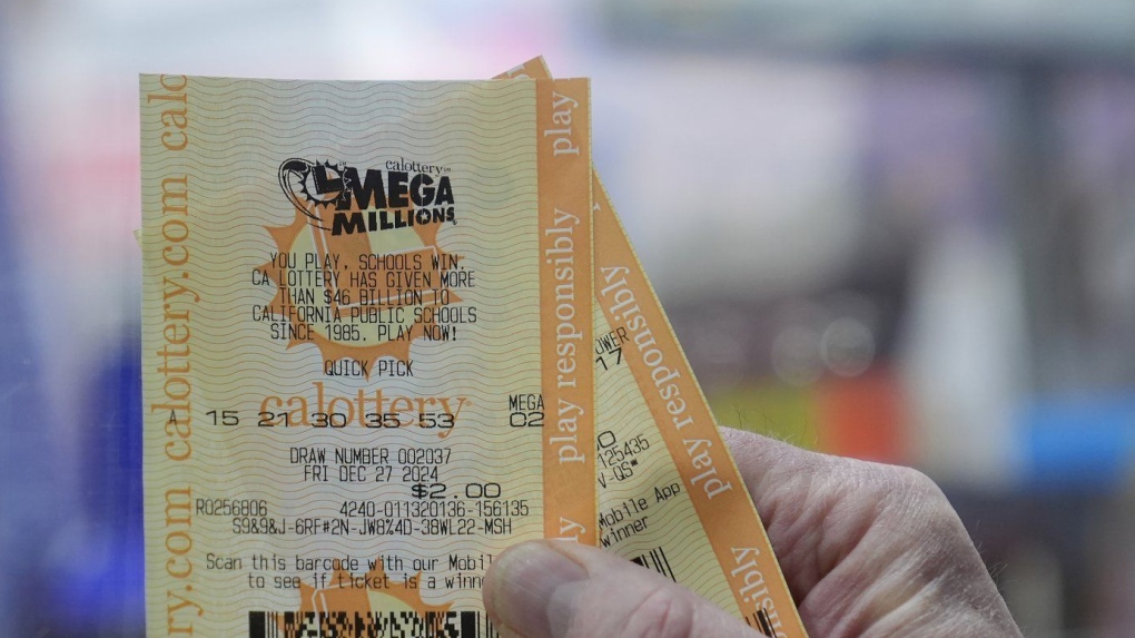 A man holds up a Mega Millions ticket at Rossi's Deli in San Francisco, Thursday, Dec. 26, 2024. (AP Photo/Jeff Chiu)