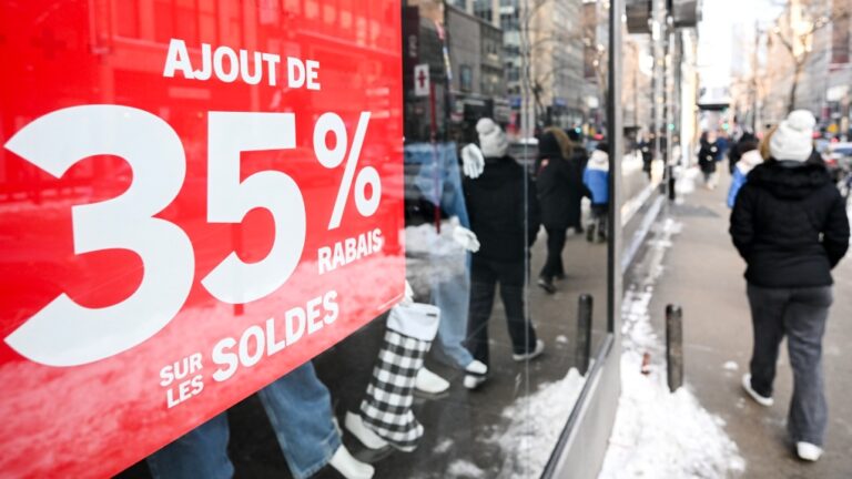 A person walks by a store offering discounts on Boxing Day in Montreal, Dec. 26, 2024. THE CANADIAN PRESS/Graham Hughes