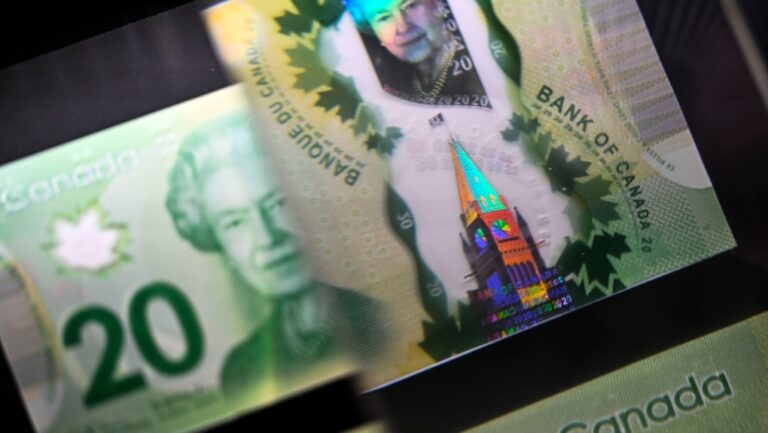 A magnifying glass enlarges the holographic image of Parliament Hill's Peace Tower on a $20 bill issued by the Bank of Canada, shown in a display case at the Bank of Canada Museum in Ottawa, on Wednesday, Sept. 4, 2024. THE CANADIAN PRESS/Justin Tang
