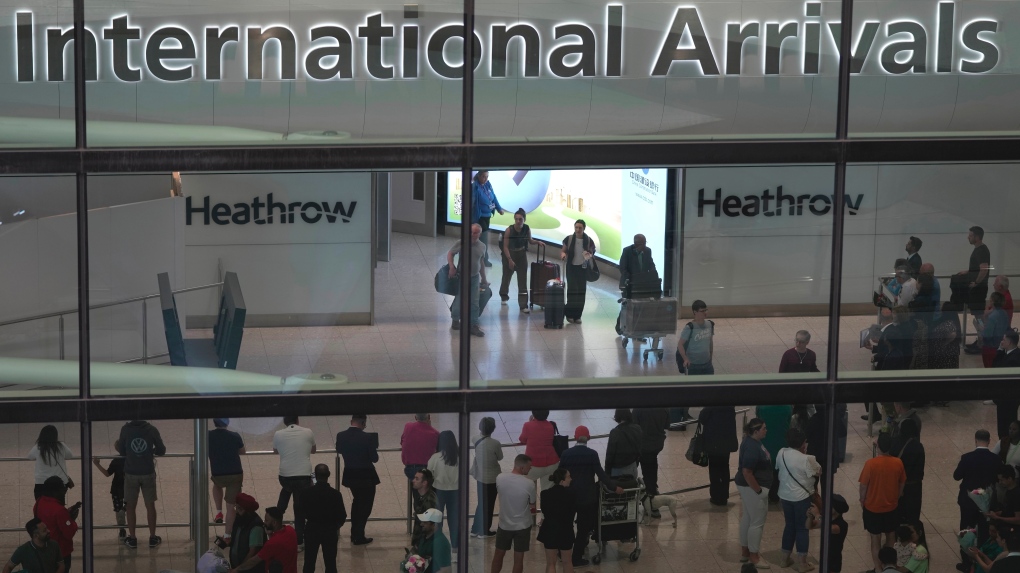 Passengers arrive at the Heathrow Airport, in London Saturday, May 27, 2023. Passengers flying into the UK are facing delays at passport controls due to the e-gates are not working. (AP Photo/Kin Cheung)