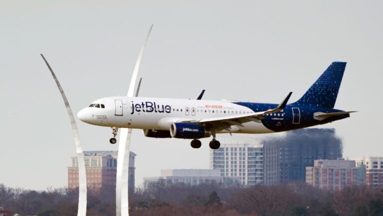 A JetBlue passenger flight passes the Air Force Memorial as it prepares to land at Reagan Washington National Airport in Arlington, Va., across the Potomac River from Washington, Jan. 19, 2022. (AP Photo/J. Scott Applewhite)